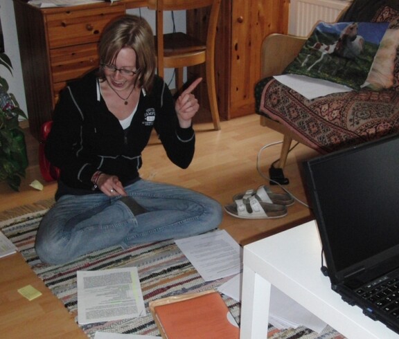 Eine Jugendliche sitzt in ihrem Zimmer und lernt.