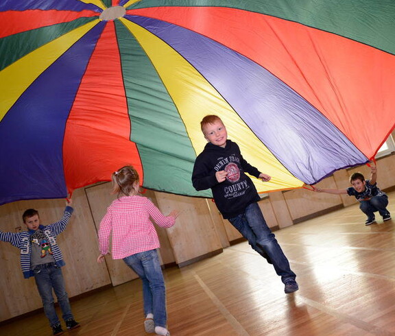 Kinder im Turnsaal mit einem Spieltuch