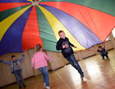 Kinder im Turnsaal mit einem Spieltuch
