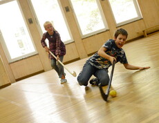 Kinder beim Hockeyspielen im Turnsaal