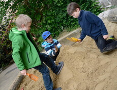 Drei Kinder beim Sandhaufenspielen
