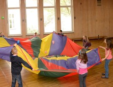 Kinder im Turnsaal mit einem Spieltuch