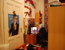 Eine Jugendliche sitzt in ihrem Zimmer am Schreibtisch.