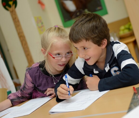 Zwei Kinder machen zusammen die Hausaufgabe