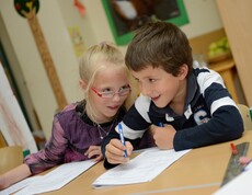 Zwei Kinder machen zusammen die Hausaufgabe