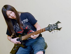 Ein Mädchen spielt auf einer E-Gitarre.
